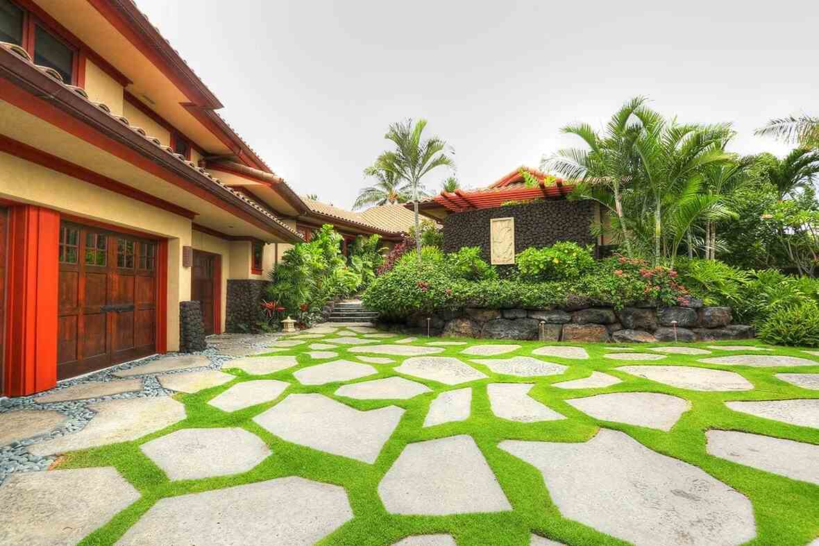 A vibrant garden with lush greenery, colorful plants, and a stone pathway winding through the foliage.